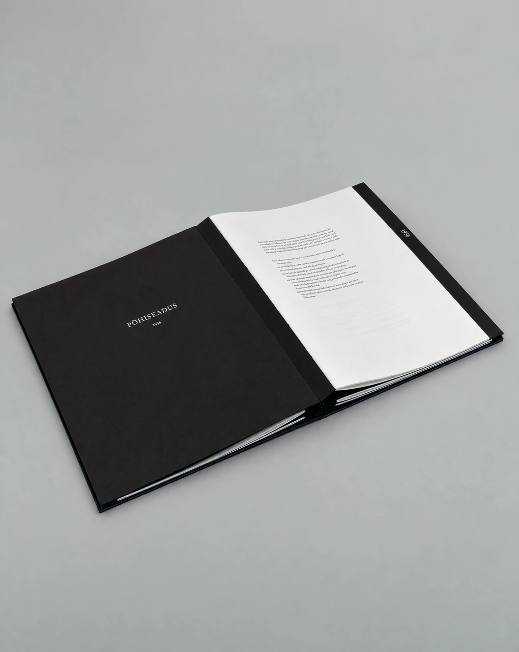 The open volume: a black divider reading Põhiseadus 1920 on the left, the text of the constitution on white paper on the right