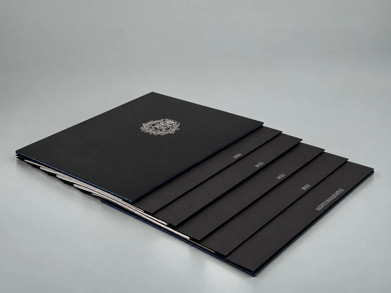 Black leather-covered volume of constitutions with a silver coat of arms; the divider edges read 1920, 1934, 1938 and 1992