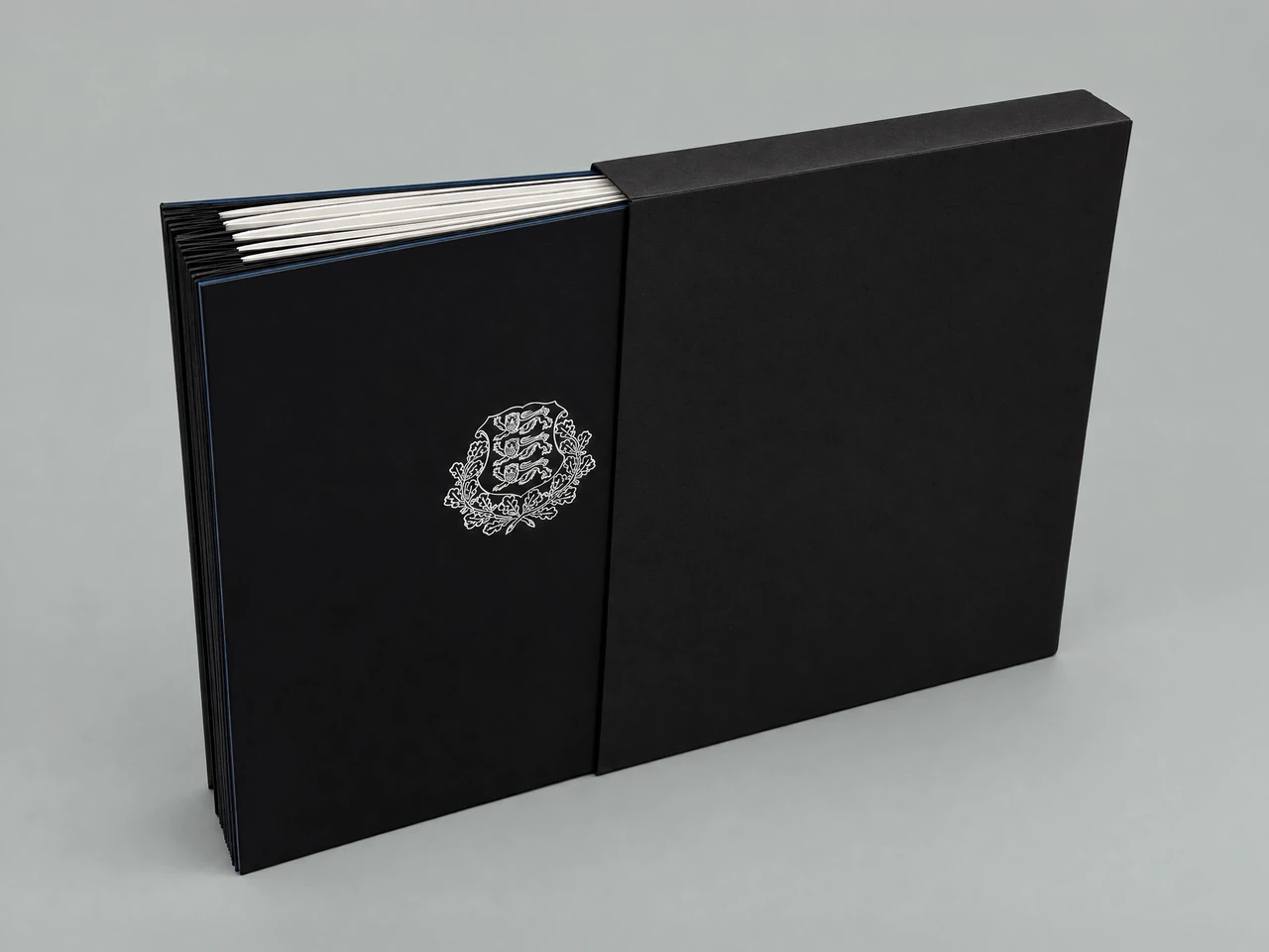 The volume of constitutions half out of its black slipcase, a silver coat of arms on the front cover